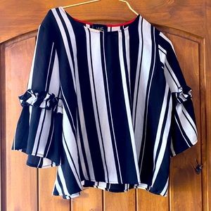 This is a black and white striped shirt with ruffle sleeves.